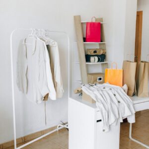 A modern interior with shopping bags, clothing rack, and minimalist design elements.